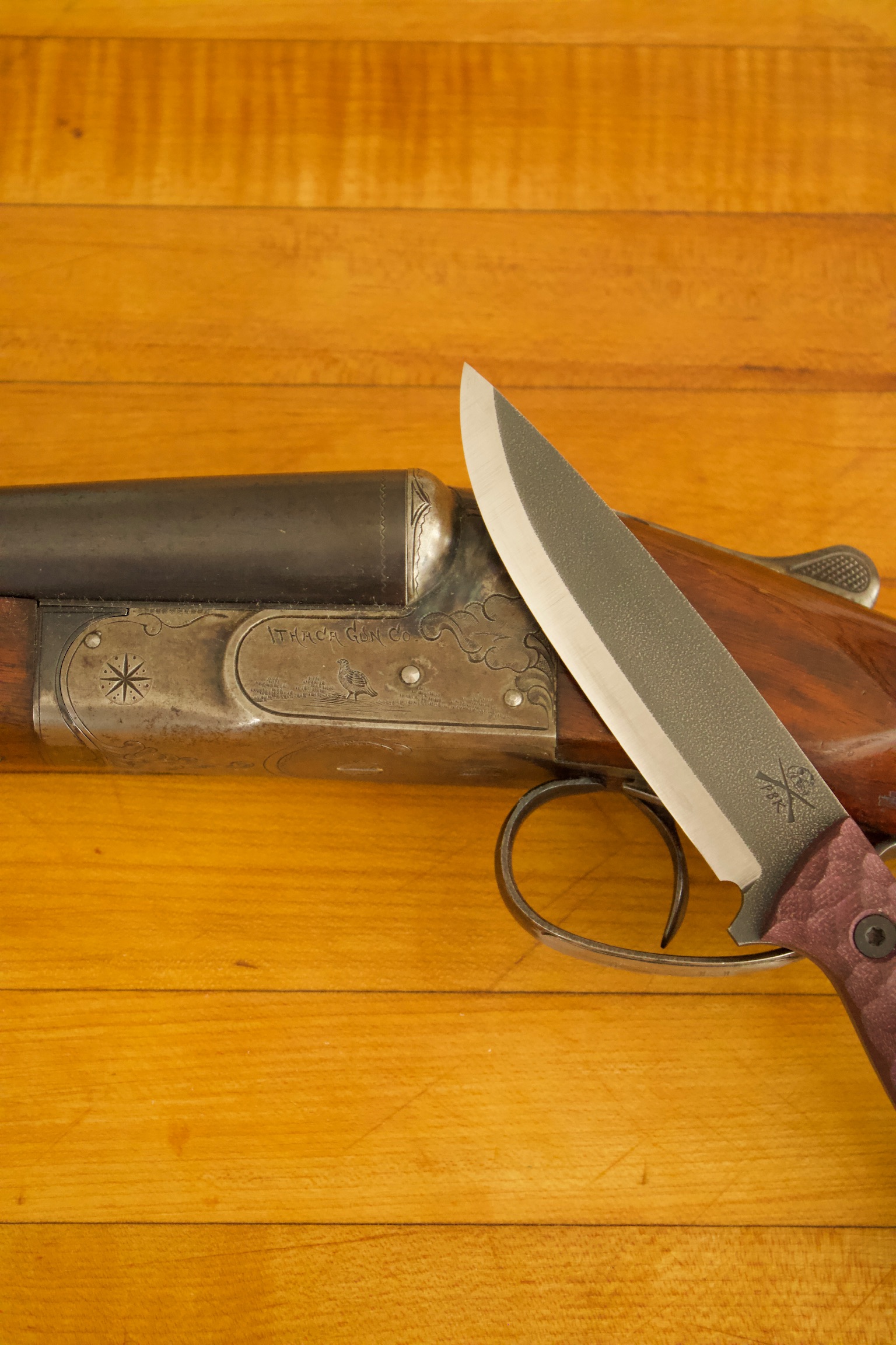 A chef knife and other finished blades arranged on a worktop