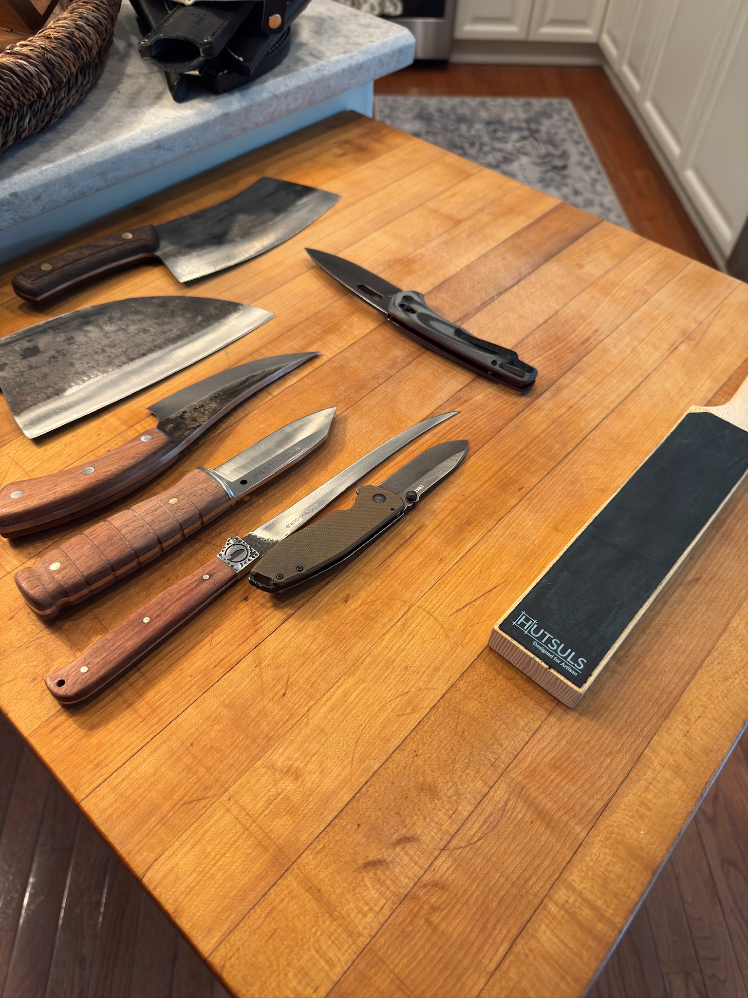 A folded pocket knife on a wood work surface